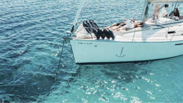 Velero fondeado en cala cristalina de la costa de Menorca